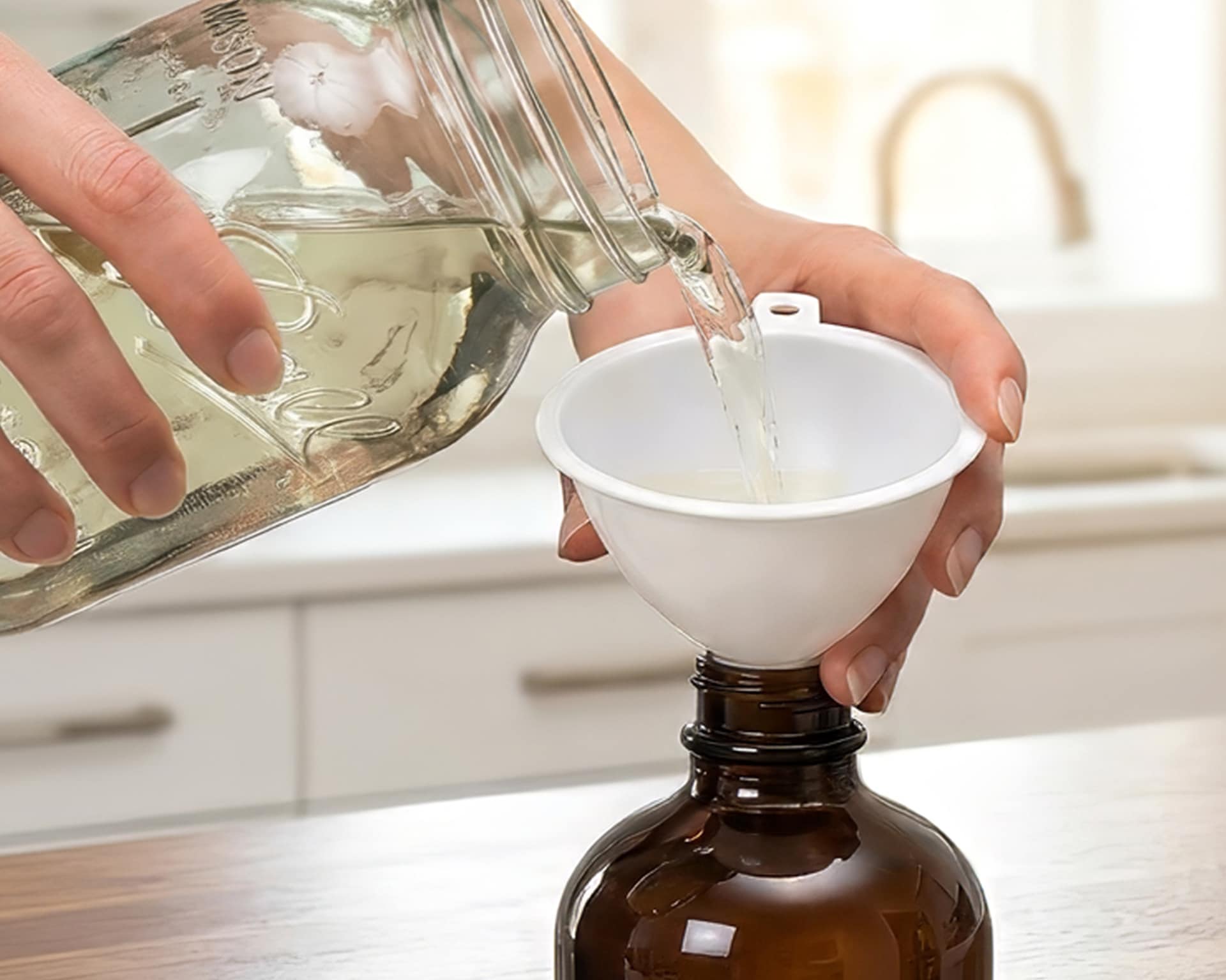 Pouring the finished batch into a dark glass storage jar